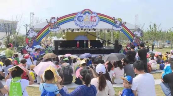 图说:游客在户外观看舞台表演。