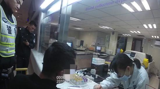 图说:民警带危险驾驶嫌疑人至医院作酒精抽血检测。普陀公安分局供图