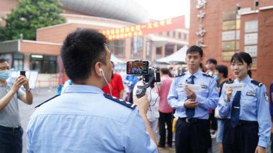 图说：民警在 考点门 前 现场直播 护考