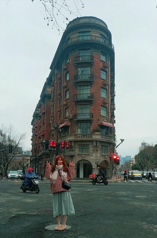 图说:市民站在马路当中,摆着各种造型同武康大楼合影,全然不顾安全