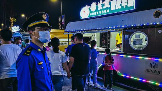 图说:城管执法队员在夜市中巡查 采访对象供图