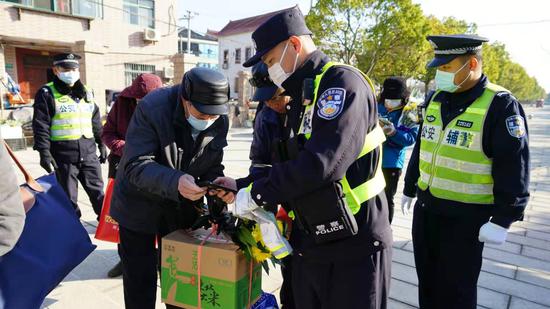 金山分局枫泾派出所民警徐君在枫泾公墓帮助祭扫老人操作手机出示健康码入园