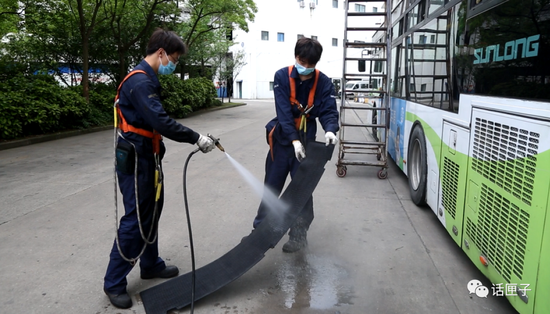 地面工作人员打开车尾部挡板,对空调压缩机进行维护保养