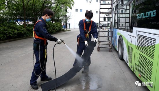 地面工作人员打开车尾部挡板，对空调压缩机进行维护保养