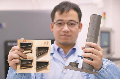 科研人员展示用同轴送丝激光金属3D打印机打印出来的零部件。 本报见习记者 赖鑫琳 摄