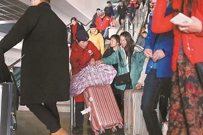接车员接车员王秋燕帮乘客搬运大件行李。