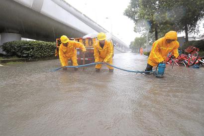 昨天,受台风影响,申城疾风暴雨,多条道路出现积水,市政部门出动移动泵车抢排积水。 本报记者 蒋迪雯 摄