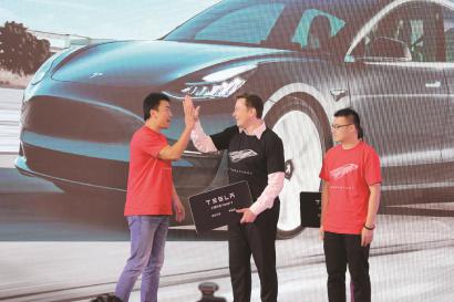 昨天,特斯拉中国制造Model 3开启全面交付,马斯克(中)向首批社会车主代表交付车辆。 本报记者 祝越摄