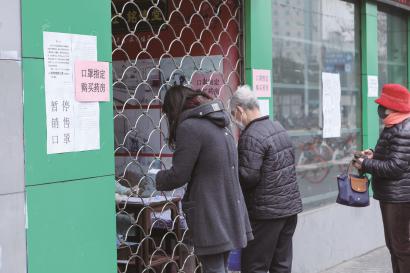 右上图：居民凭预约在长海路上一家药房顺利买到口罩。本报记者 叶辰亮 摄