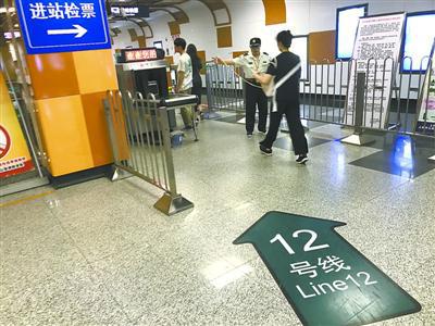 12号线安检员拉起“封锁线”,引导乘客安检。邬林桦 摄