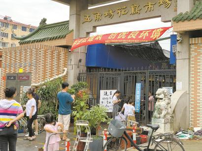7月1日,五角场花鸟市场大门紧闭,一些居民在门口观望。