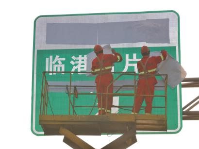 昨天早上,工人将一块指向“临港新片区”的崭新路牌换上。 本报记者 赖鑫琳 摄