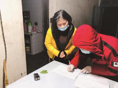 昨晚,金山廊下镇工作人员上门发放《告知书》,并让重点地区来沪人员签下《居家隔离观察承诺书》。(廊下信息中心供图)
