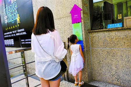 上海海洋水族馆售票处,一位家长让孩子主动到标尺下量身高,确认无误后再买票。黄尖尖 摄