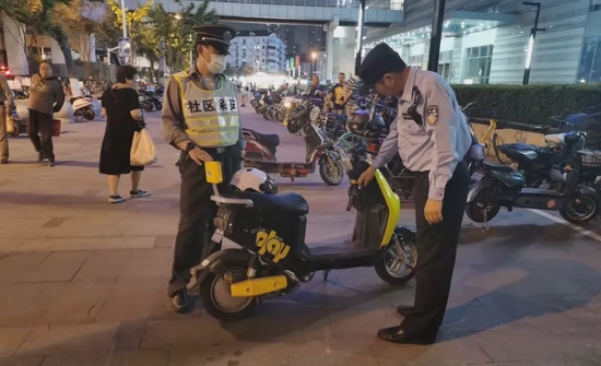 ▲民警为未上锁电瓶车进行“爱心贴单”