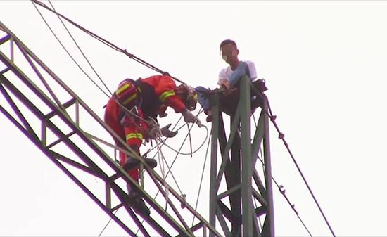 消防队员正在营救轻生男子 来源：上海消防