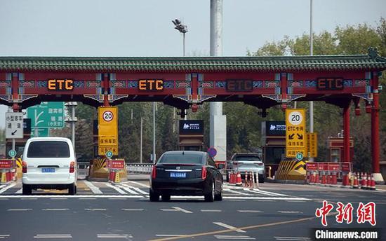 4月10日，机动车正通过北京机场高速收费站“电子不停车收费系统”（ETC）通道。 中新社记者 侯宇 摄