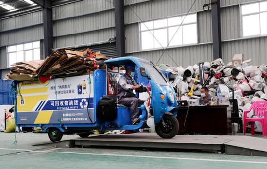 工作人员驾驶一辆可回收物清运车,在上海闵行区浦锦街道的“两网融合”中转服务站内的地磅上称重(5月27日摄)。新华社记者 方喆 摄