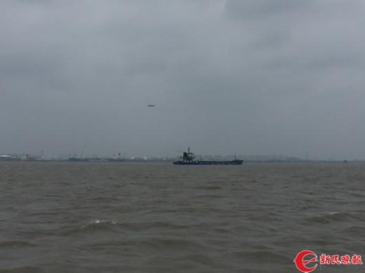 图片说明:上海海事的救助直升机一直在事发锚地上空盘旋搜救 曹刚 摄