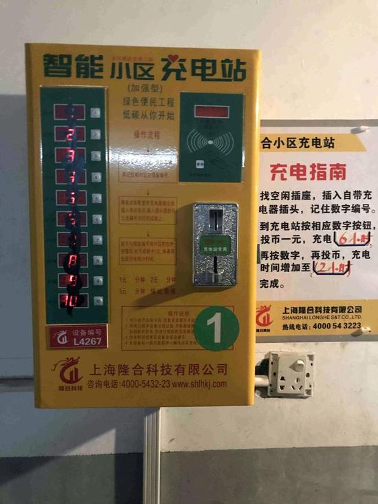 △图为小区安装的智能充电站,上面标有操作说明和收费,左侧按钮被居民泼上了黑漆。