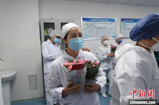 金银潭医院上海医疗队的女医护人员正在挑选心爱的鲜花。这批鲜花是由拼多多联合中铁昆明局集团开通“鲜花专列”,协助云南花农捐赠到了武汉。 拼多多供图