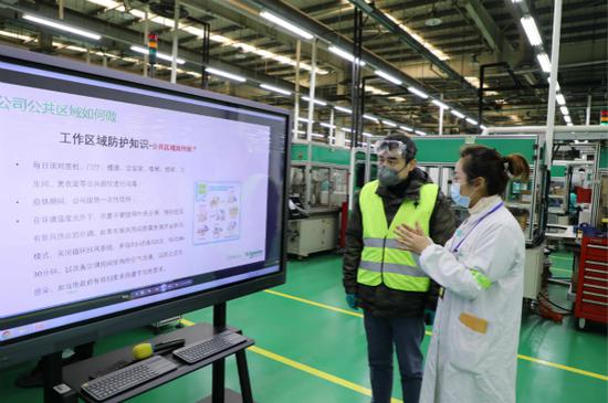 图说:社区卫生服务中心人员前往企业指导防疫工作。普陀区新闻办供图