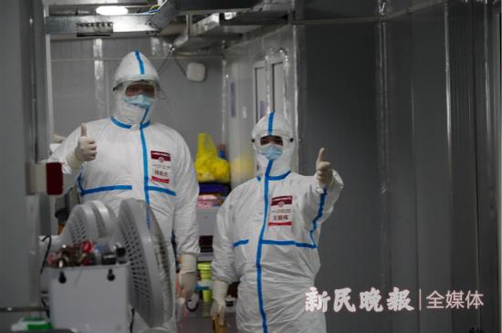 图说：两名上海国家中医医疗队队员准备进入隔离病房 新民晚报记者 郜阳 摄

