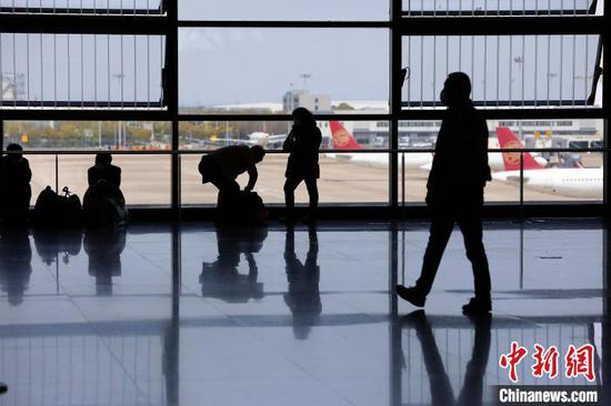 旅客在浦东机场T2航站楼内等待办理登机手续。 殷立勤 摄