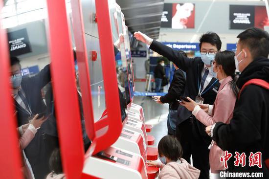旅客在浦东机场T2航站楼内办理登机手续。 殷立勤 摄