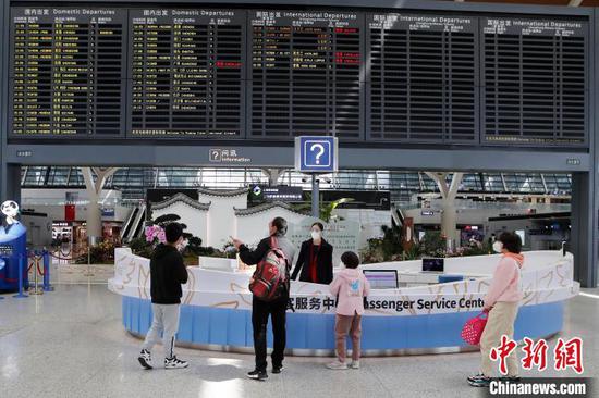 旅客在浦东机场T2航站楼内询问相关登机信息。 殷立勤 摄