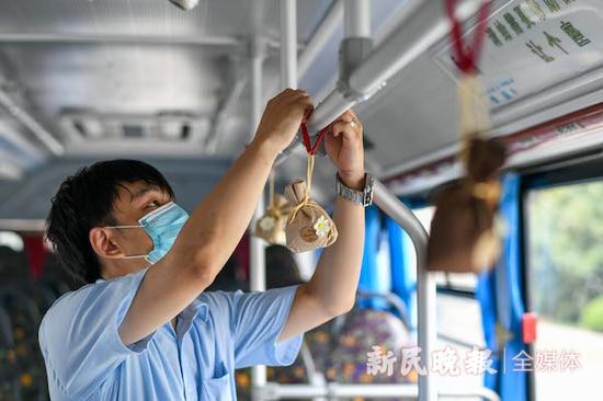 图说:驾驶员在公交扶手上挂上香囊杀菌消毒 新民晚报记者 陈梦泽 摄