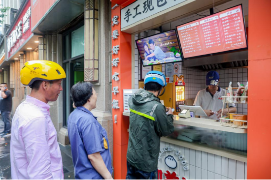 户外工作者在东安路店门口排队领取餐包