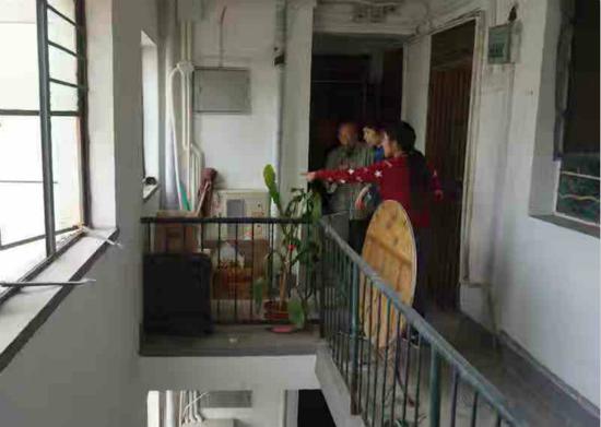 图说:物业工作人员检查楼道堆物情况。 宏新摄