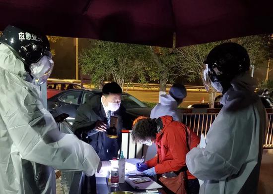 境外返沪人员在小区门口登记。青浦区新闻办供图

