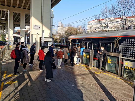 图说：上午7时45分，十多名乘客在71路凯旋路站台有序排队上车 来源/黄罗成 摄