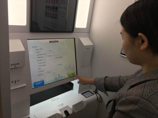 图说:市民在操作办理。