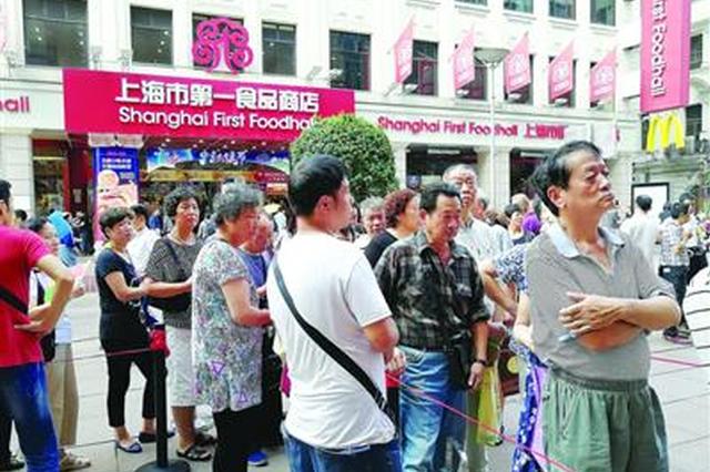 一名黄牛试图向排队购买月饼的人招揽生意