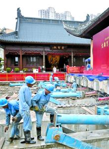 2017年9月7日,46只平移千斤顶承载着2000吨的大雄宝殿缓缓地稳 步前进。图为工人正在为推进作准备。