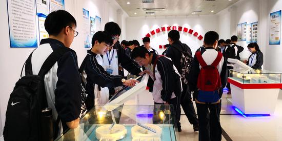 学生们在体验污水处理工艺流程的触摸屏教学演示