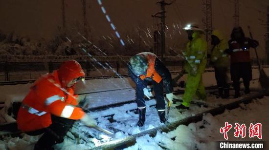 资料图：合肥电务段职工在合武铁路沿线清除积雪。　唐述虎 摄