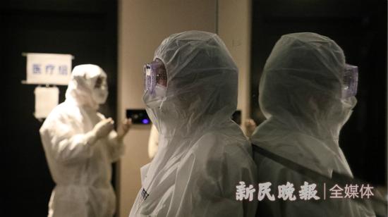 图说：接到通知，医务人员换上防护服，准备接收第一批隔离人员入住。新民晚报记者 张剑 摄

