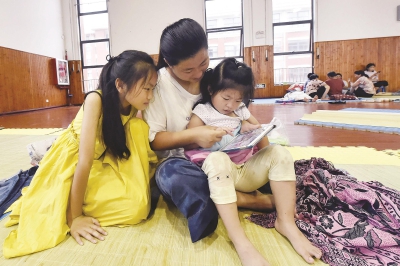 在崇明长兴岛平安小学安置点,渔民们围坐在一起休息,等候台风过境。本报记者赵立荣摄