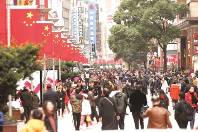 南京路步行街上,红旗随风飘扬,与熙熙攘攘的游人相映成趣。本报记者叶辰亮摄