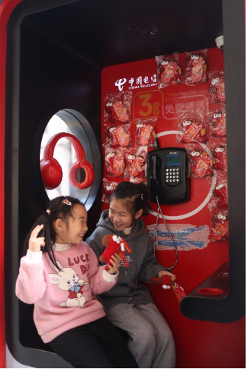 （上海电信在街头的公话亭为市民送上新年祝福）