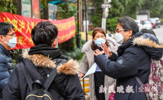 图说:志愿者朴昌柱(右一)为外籍居民进行翻译。新民晚报记者 孙中钦 摄