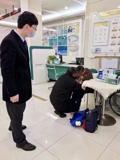 网点大堂经理吴周平将爷孙俩带到休息区,给他们准备了酒精湿纸等便民用品