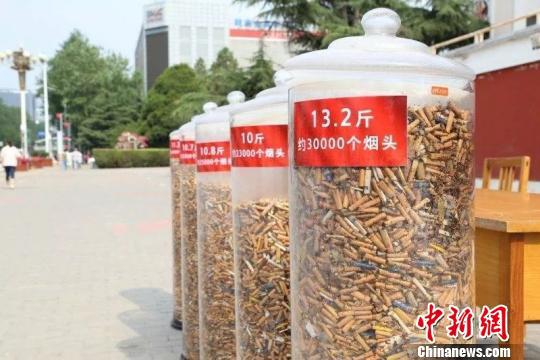 长治市潞州区广场,一个个透明的玻璃罐整齐排列,里面密密麻麻堆着上万个被人丢弃的烟头,看起来十分壮观。 冯嘉伟 摄
