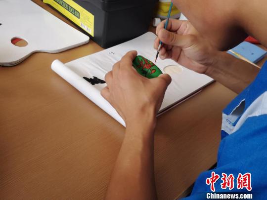 在教育矫正中心,学员们正在木质小玩具上专心地绘制图案 范丽芳 摄