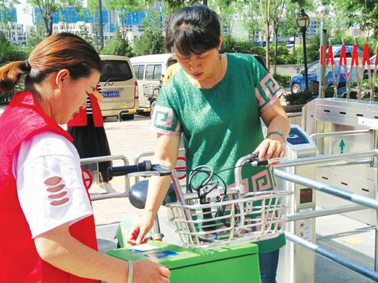 市民正在通过闸机感应器进行还车操作。记者 李兵 摄