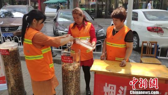 长治市潞州区环卫处开展“烟头不落地、城市更美丽”环保宣传活动,集中展示“清理烟头专项治理行动”开展以来的清理成果。 冯嘉伟 摄